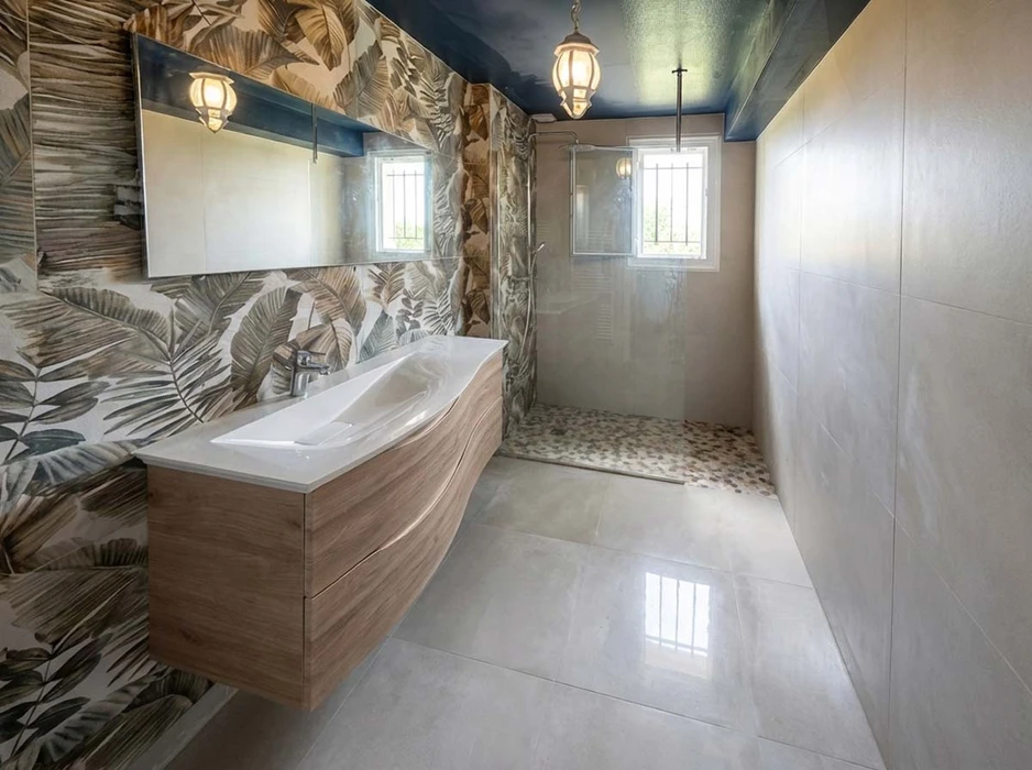 Salle de bain moderne avec douche à l'italienne, meuble vasque suspendu en bois clair avec plan vasque blanc thermoformé, robinetterie chromée