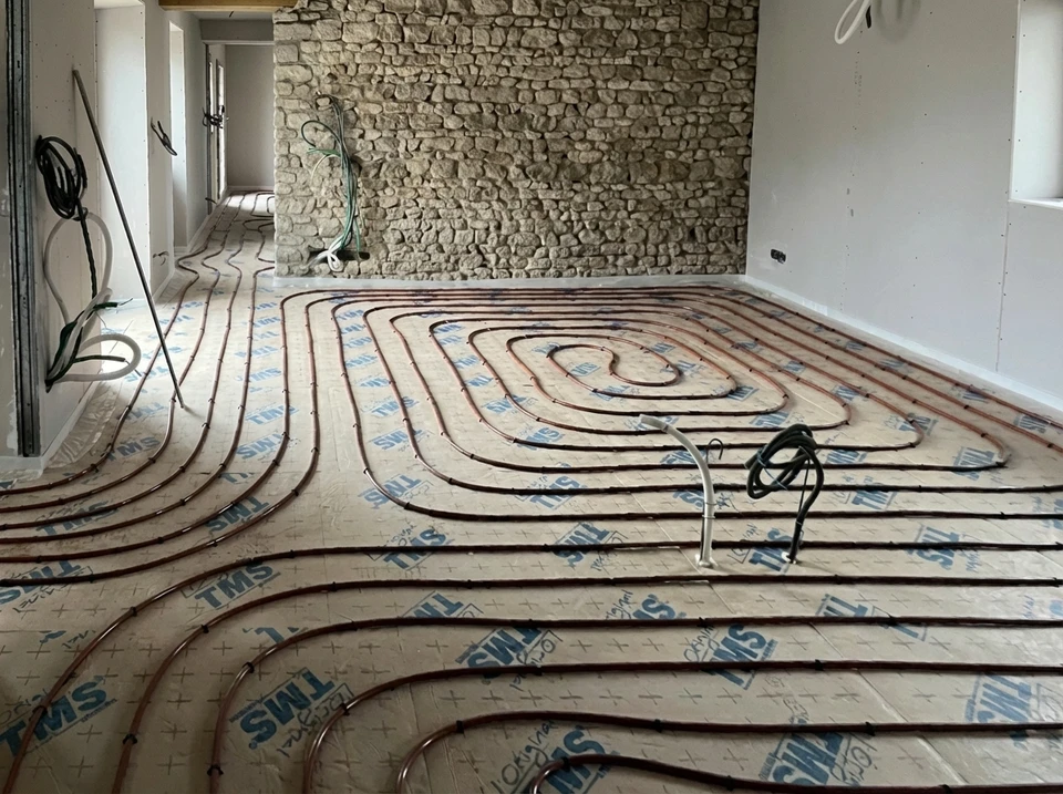 Intérieur résidentiel avec plancher chauffant hydronique en cours d'installation
